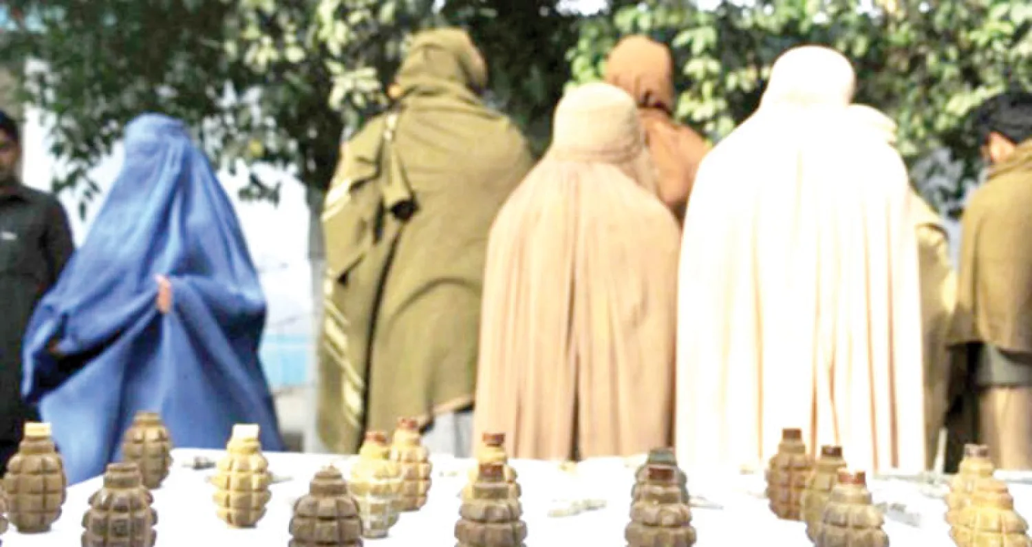 صورة من داخل مجلة «طالبان» النسائية الجديدة وتظهر نساء خلفهن قنابل