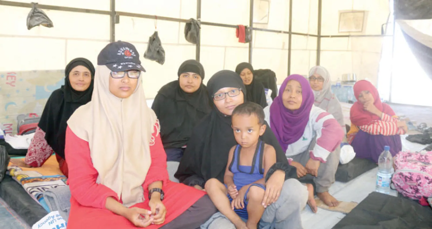 العائلات الإندونيسية في مخيم عين عيسى وإلى اليسار نورا خيرت دنيا التي قطعت عائلتها مسافة 8500 كيلومتر بحثاً عن سراب («الشرق الأوسط»)