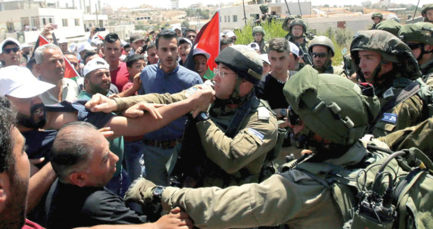 مواجهة بين فلسطينيين وجنود الاحتلال جنوب الخليل أمس (رويترز)