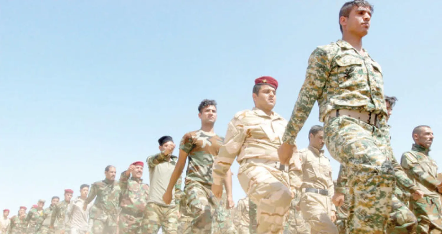 استعراض لمقاتلين في «الحشد الشعبي» في داقوق قرب كركوك أمس (رويترز)