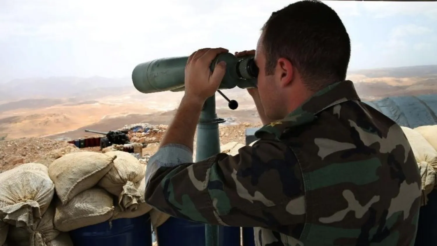 In this 2016 photo, a Lebanese army first lieutenant looks through binoculars toward areas controlled by ISIS on the edge of Arsal, on the Syrian border, in northeast Lebanon. (AP)