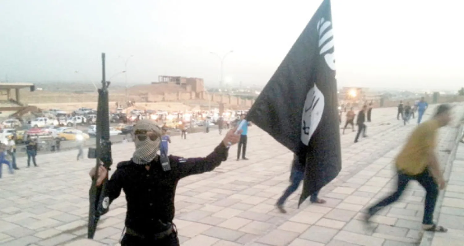 مسلح يحمل علم «داعش» في وسط الموصل قبل طرد الإرهابيين منها (رويترز)