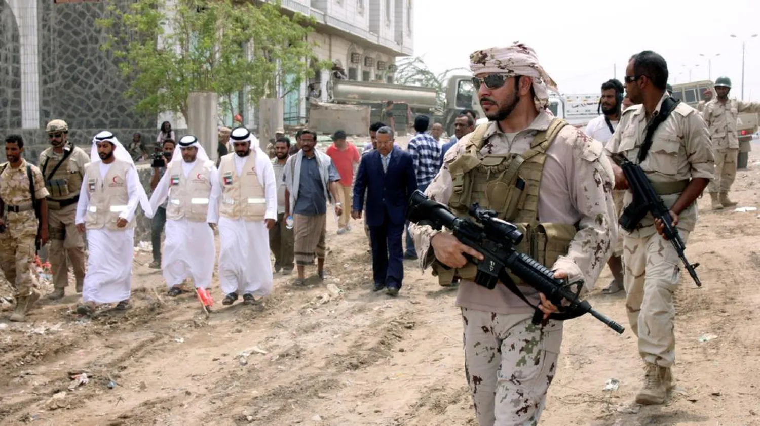 A UAE soldier escorts Yemeni Prime Minister Ahmed Obeid bin Daghr during a visit to the liberated Red Sea port city of Mokha on August 6, 2017. (Reuters)