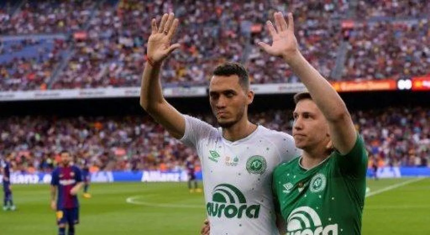 مدافع تشابيكوينسي نيتو (يسار) وحارس الفريق السابق جاكسون فولمان أمام جماهير نادي برشلونة على ملعب كامب نو (أ.ف.ب)