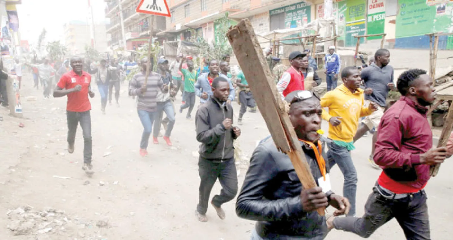 متظاهرون يحملون العصيّ في كيسومو أحد معاقل المعارضة أمس (رويترز)