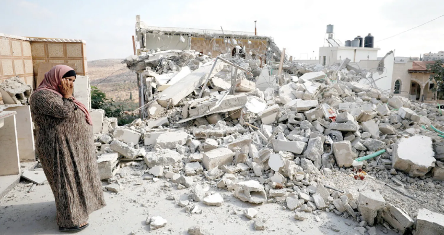 والدة شاب فلسطيني هدمت إسرائيل منزله في قرية دير أبو مشعل قرب رام الله أمس بحجة تنفيذه عملية في القدس (رويترز)