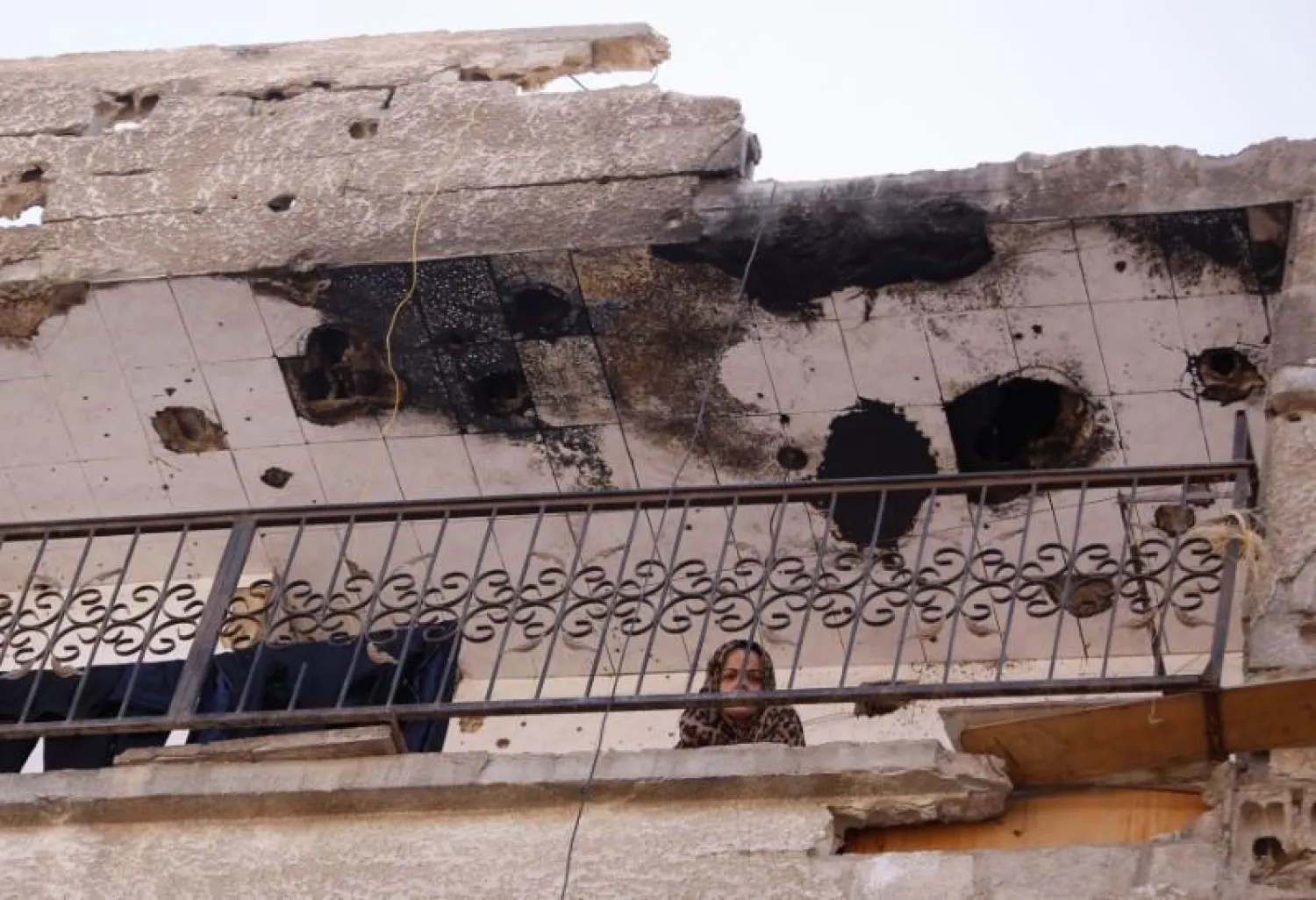 A woman is seen at a balcony in Moadamiya, in Damascus, Syria July 23, 2017. (Reuters)
