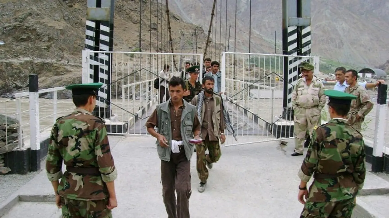 Tajik border guards checking identification documents of people crossing the Tajik-Afghan border on a bridge across the Panj River outside the city of Panj, August 2010. (AFP)