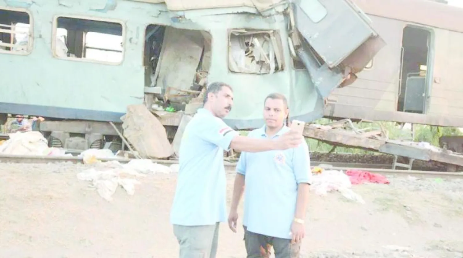 مسعفان يلتقطان صورة «سيلفي» في موقع حادث تصادم القطارين (صورة متداولة على فيسبوك)