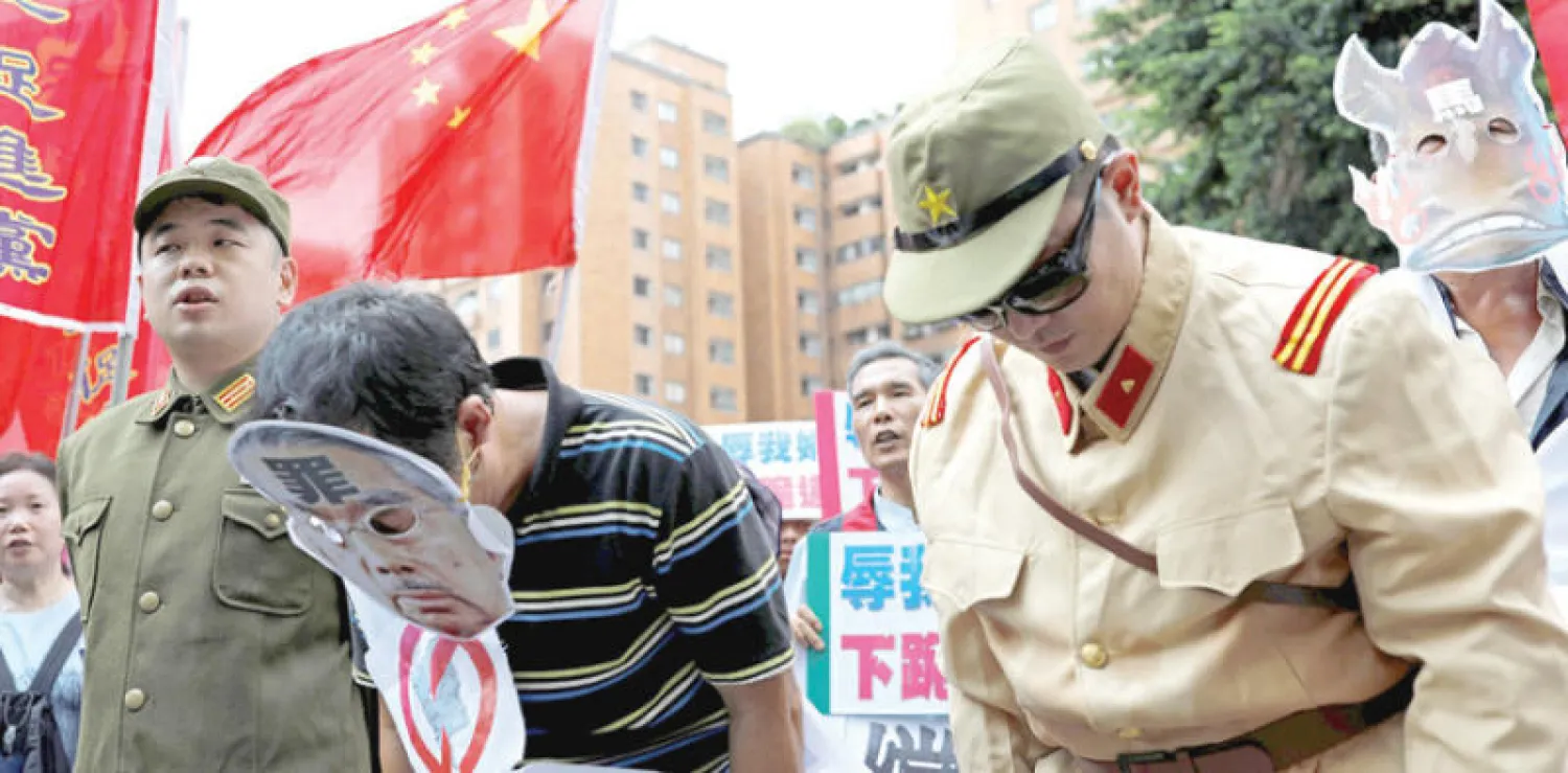 تايوانيون معارضون لليابان يمثّلون استسلام الجيش الياباني في الذكرى الـ72 للحرب العالمية الثانية في تايبه أمس (رويترز)