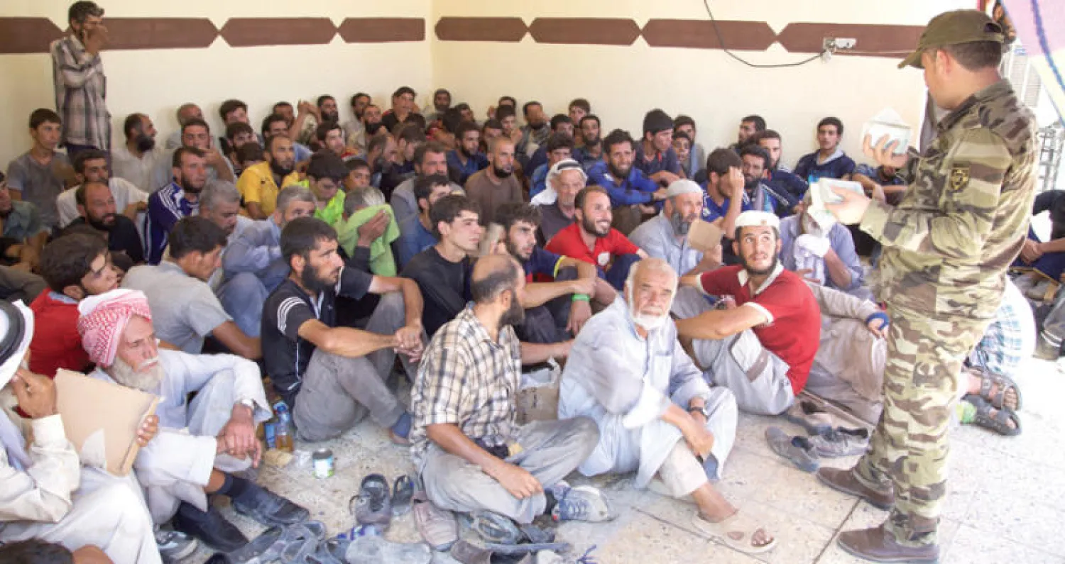 صورة بثت أمس لمدنيين هاربين من تلعفر وهم يخضعون لتدقيق أمني في مخيم لاستقبال النازحين غرب الموصل (أ.ب)