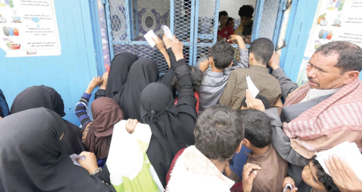 يمنيون ينتظرون الحصول على خبز مجاني من منظمة خيرية في العاصمة صنعاء أمس (إ.ب.أ)