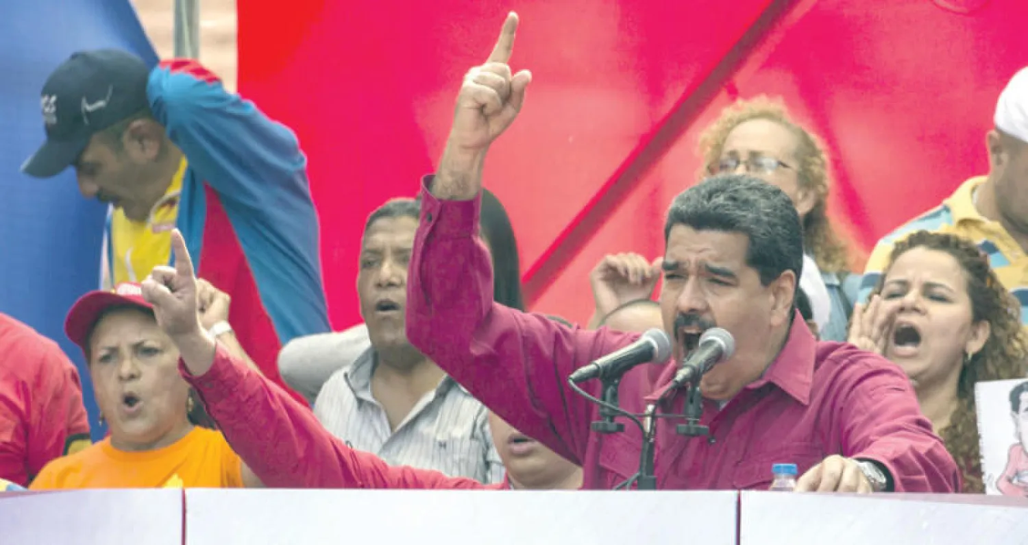 الرئيس الفنزويلي وسط مناصرين له رافضاً العمل العسكري ضد بلاده (إ.ب.أ)