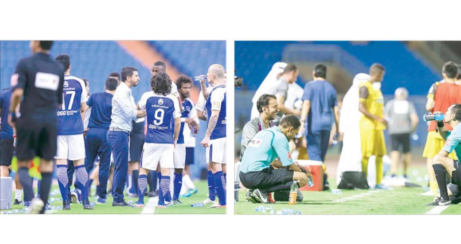 حكام إحدى المباريات يروون عطشهم خلال الوقت المستقطع (تصوير: بدر الحمد) - الأندية السعودية طلبت إيقاف المباريات لمنح اللاعبين فرصة شرب الماء (تصوير: بدر الحمد)