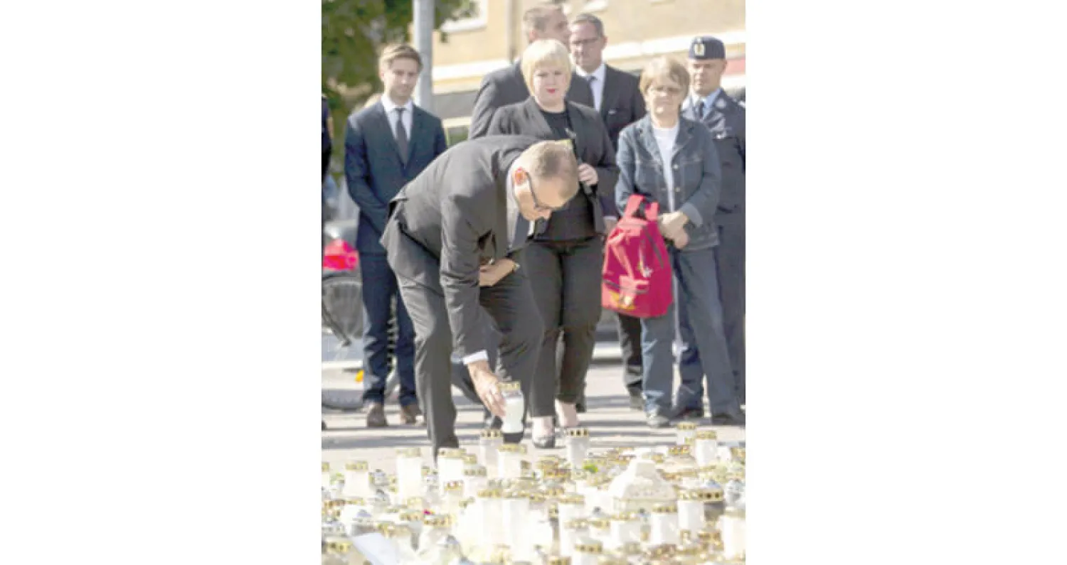 رئيس الوزراء الفنلندي يوها سيبيلا يضع إكليلاً من الورود في مكان الطعن في هجوم توركو أمس (إ.ب)