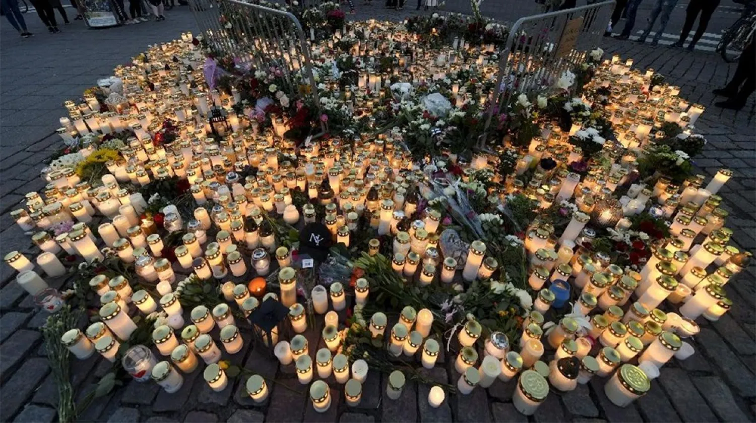 Candles and flowers have been left at the makeshift memorial for the victims of Friday's stabbings at the Turku Market Square. (AFP)