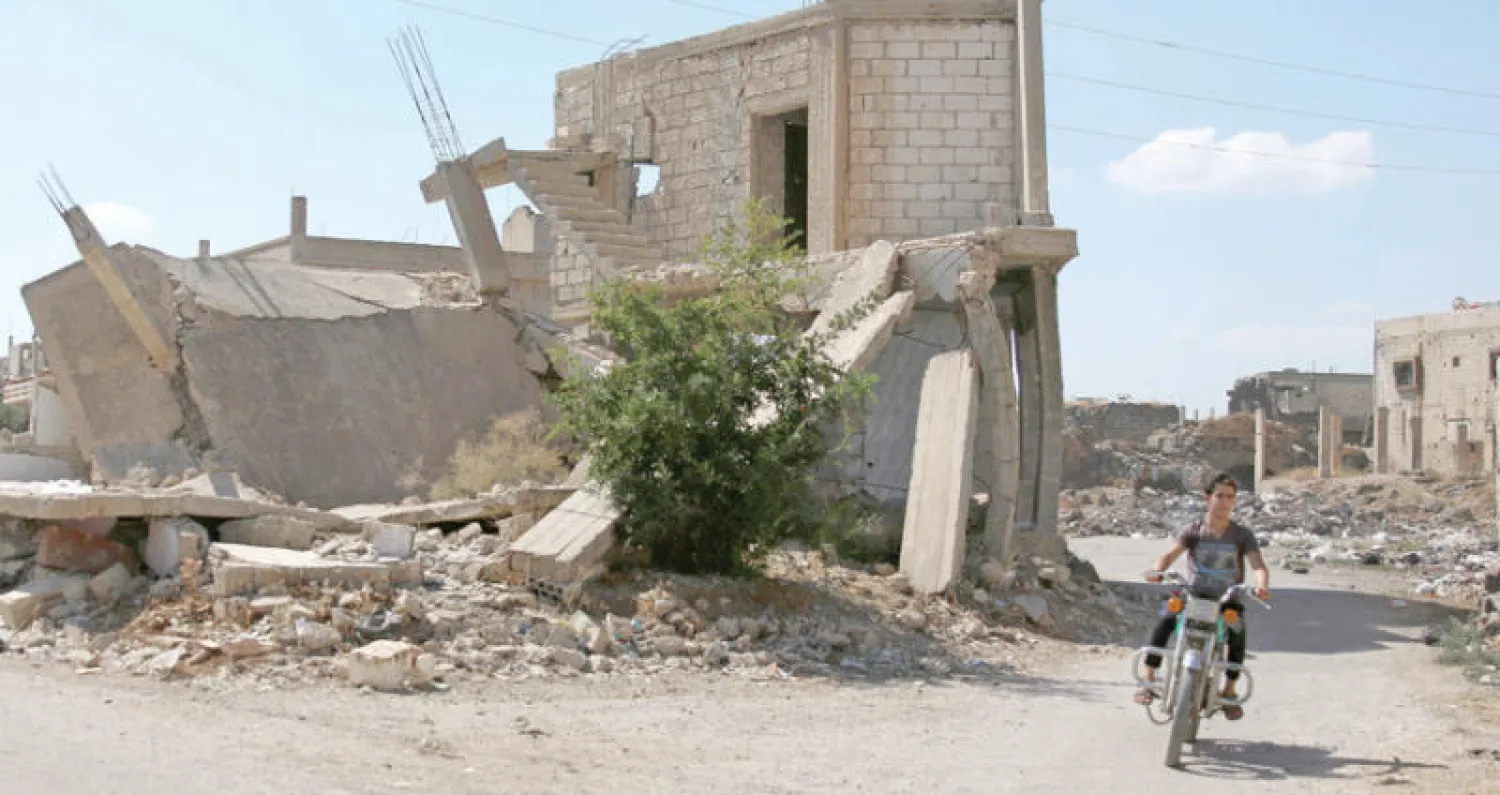 شاب على دراجته يعبر بلدة داعل التي تقع تحت سيطرة المعارضة في محافظة درعا (أ.ف.ب)