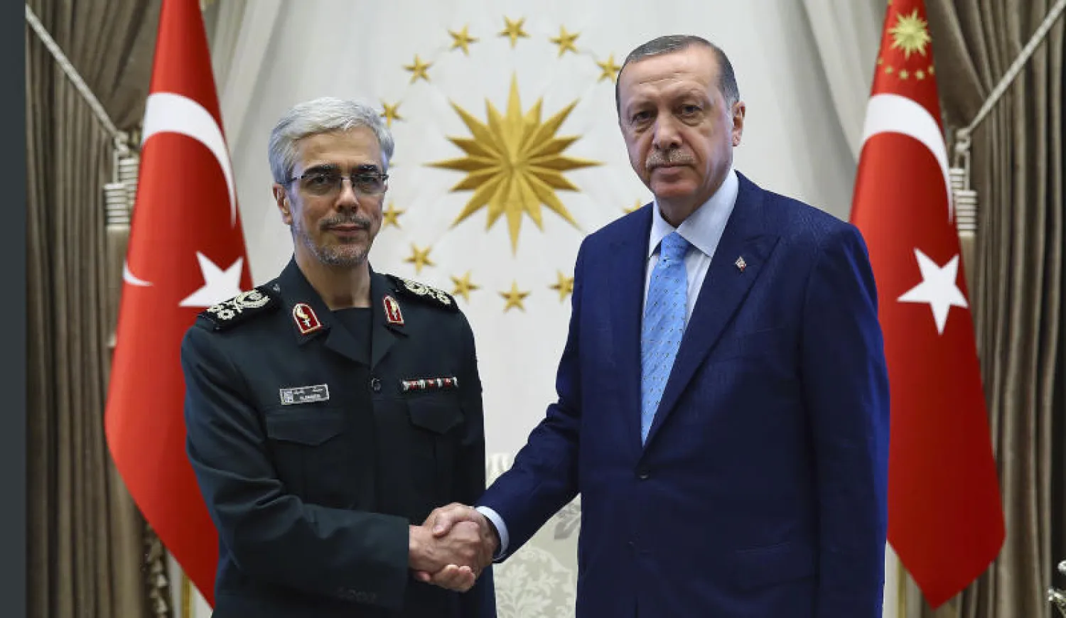 الرئيس التركي رجب طيب إردوغان (يمين) خلال استقباله رئيس الأركان العامة بالقوات المسحلة الإيرانية محمد باقري في أنقرة (أ.ب)