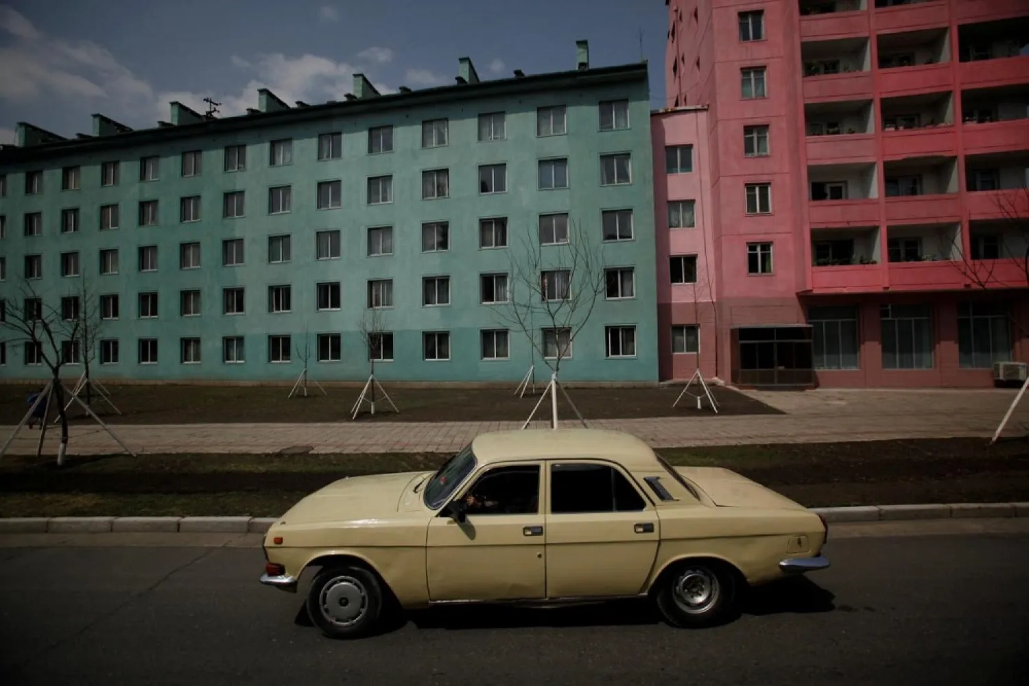 A car drives past residential buildings in Pyongyang, North Korea on April 11, 2012. (Reuters)