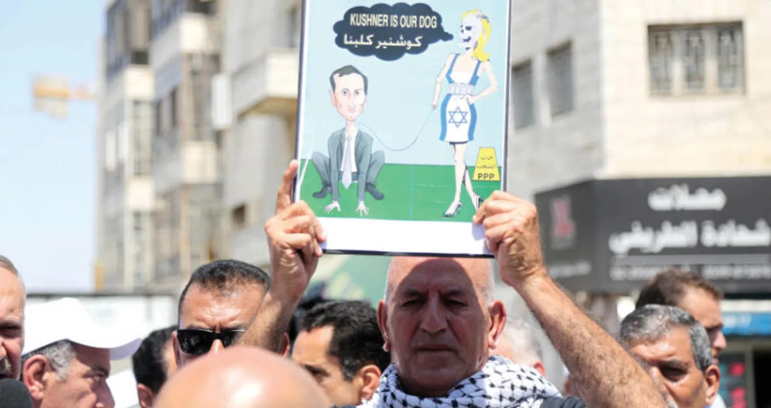 متظاهرون فلسطينيون يرفعون ملصقاً خلال احتجاجات شهدتها رام الله ضد الموقف الأميركي