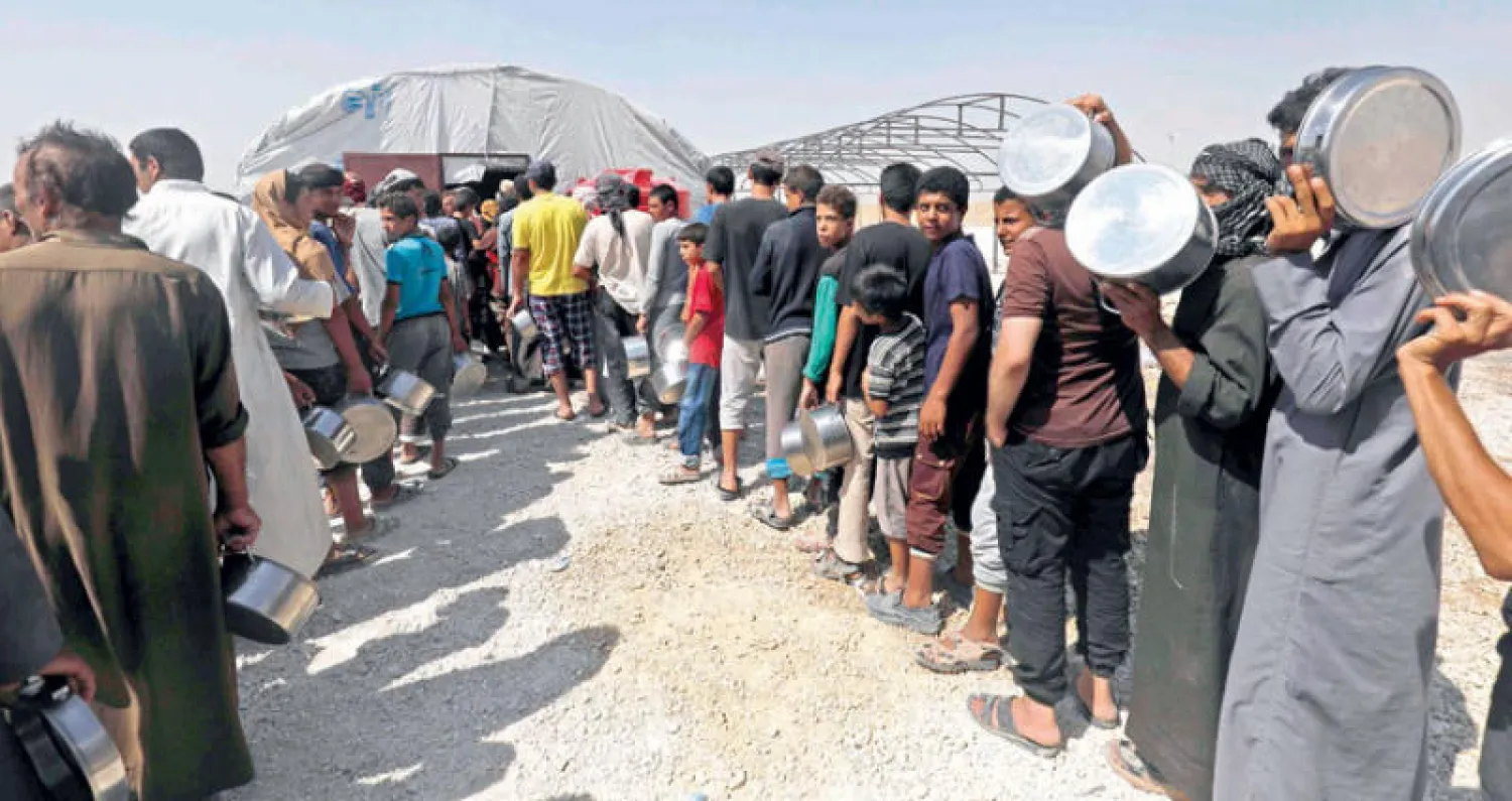 نازحون سوريون ينتظرون الحصول على المياه في راس العين شمال البلاد (أ.ف.ب)