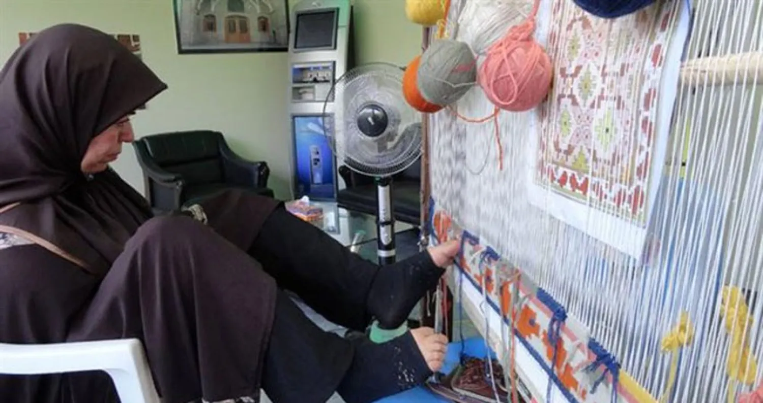 معاقة إيرانية تحوك السجاد.