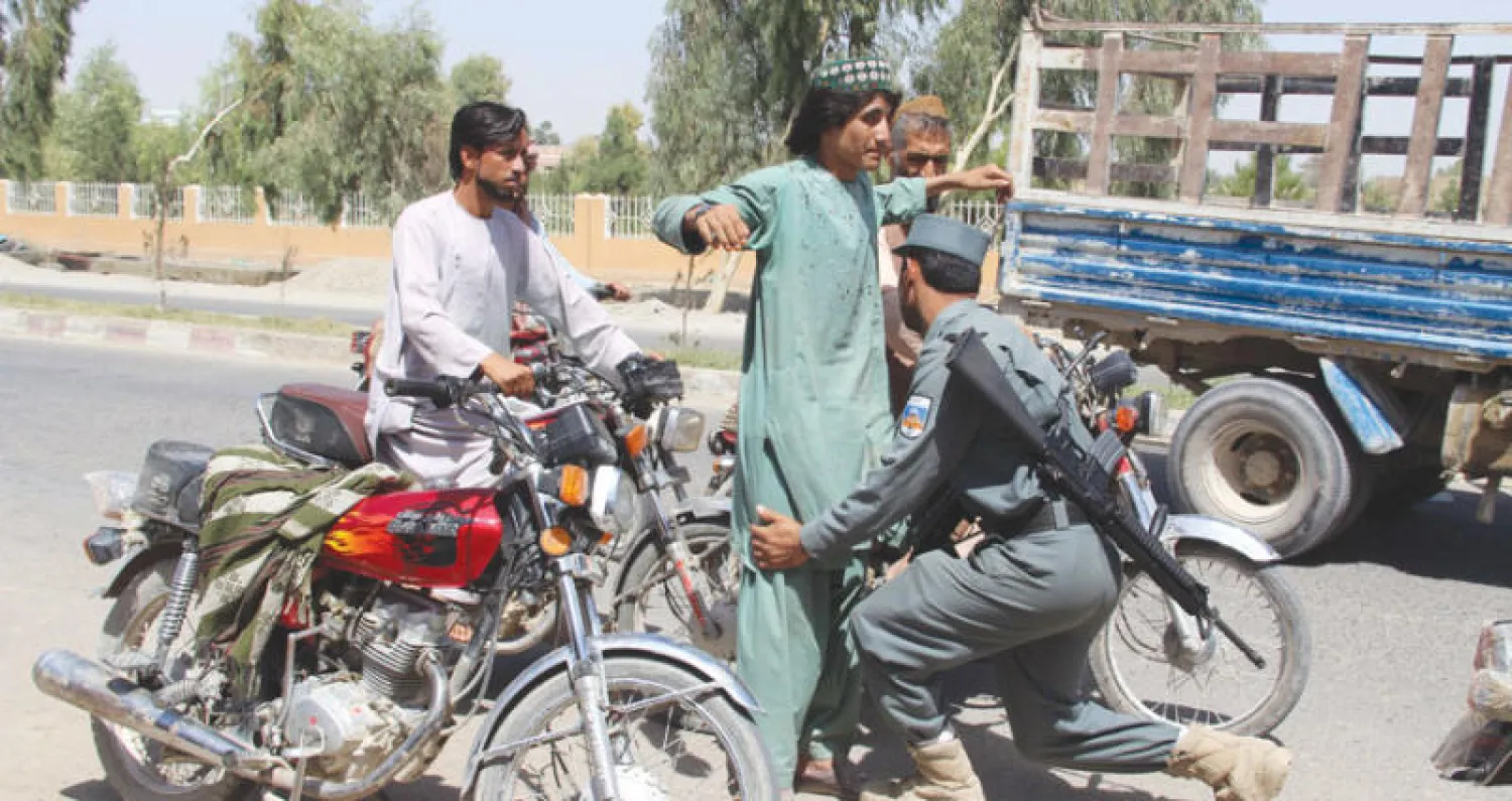 إجراءات أمنية وتفتيش مواطنين على الطريق السريعة خارج هلمند بعد هجوم استهدف قافلة لجنود أفغان جنوب البلاد في وقت متأخر أول من أمس (إ.ب.أ)