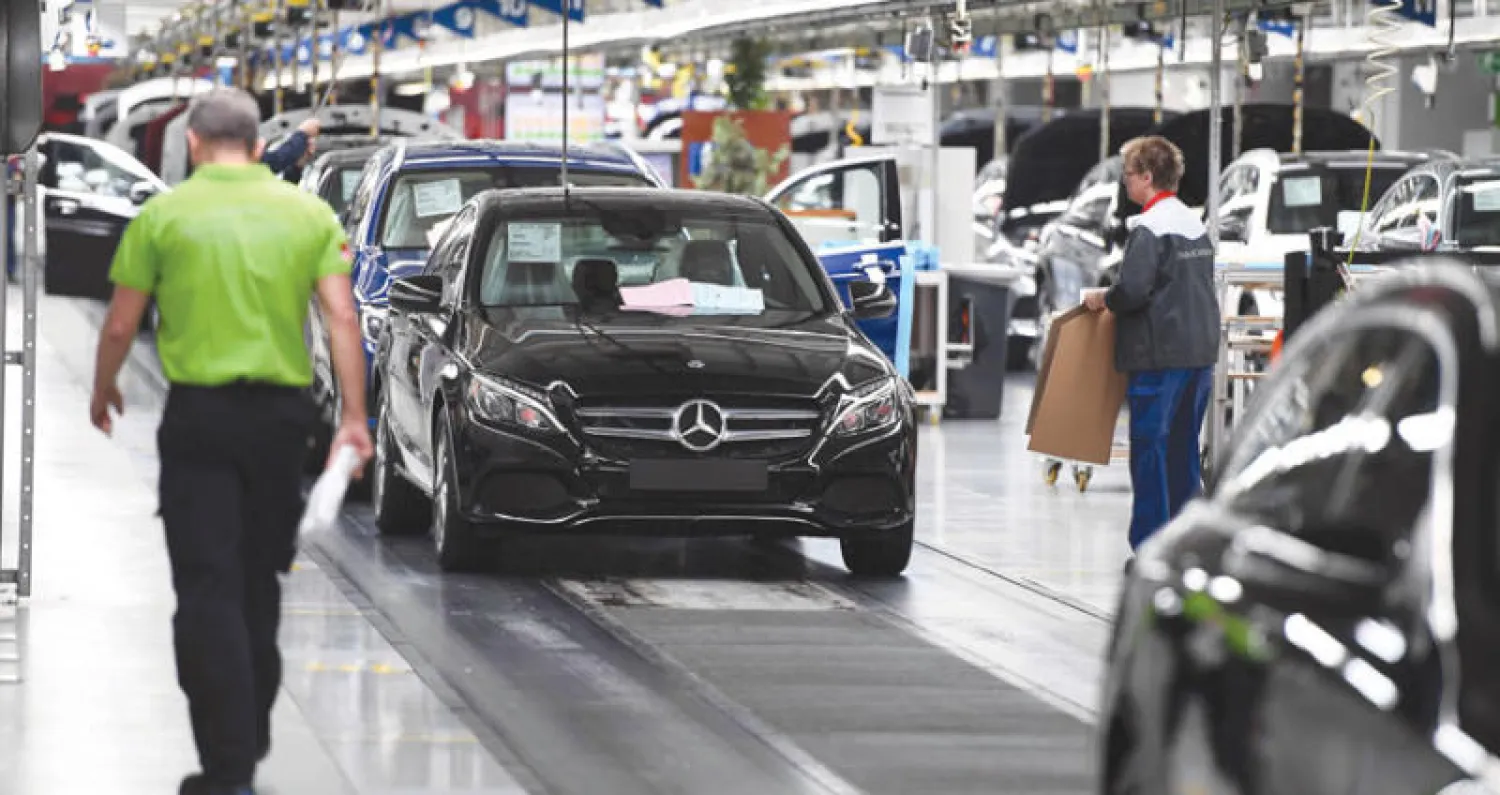 عمال يتابعون خط إنتاج سيارات مرسيدس في أحد مصانع الشركة في بريمن (غيتي)
