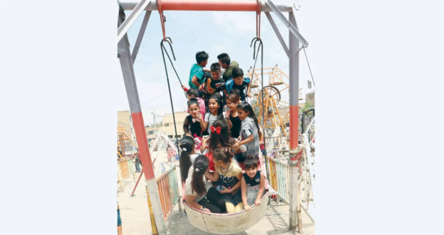 أطفال يحتفلون بعيد الأضحى في حديقة بوسط بغداد أمس (إ.ب.أ)