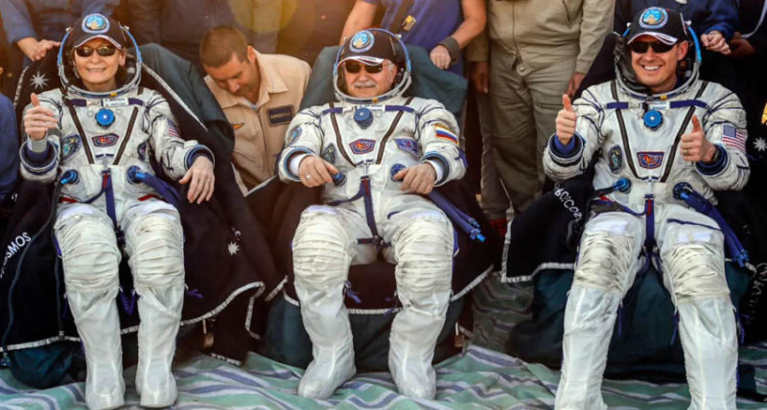 رواد الفضاء الأميركيان بيجي ويتسون وجاك فيشر والروسي فيودور يورشيخين بعد هبوطهم في كازاخستان (أ.ب)