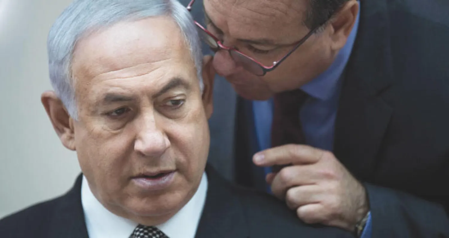 نتنياهو يستمع لمستشاره يؤاف هوروفيتس خلال اجتماع الحكومة (أ.ب)