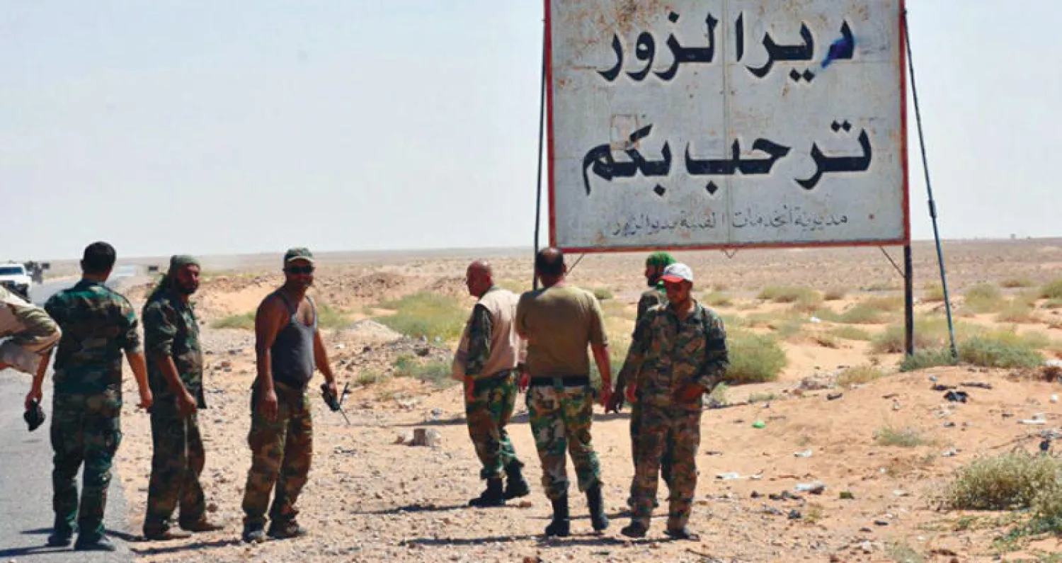 قوات تابعة للنظام السوري قرب لافتة تشير إلى دير الزور حيث اقتربت القوات من فك حصار «داعش» عن المدينة (أ.ب)