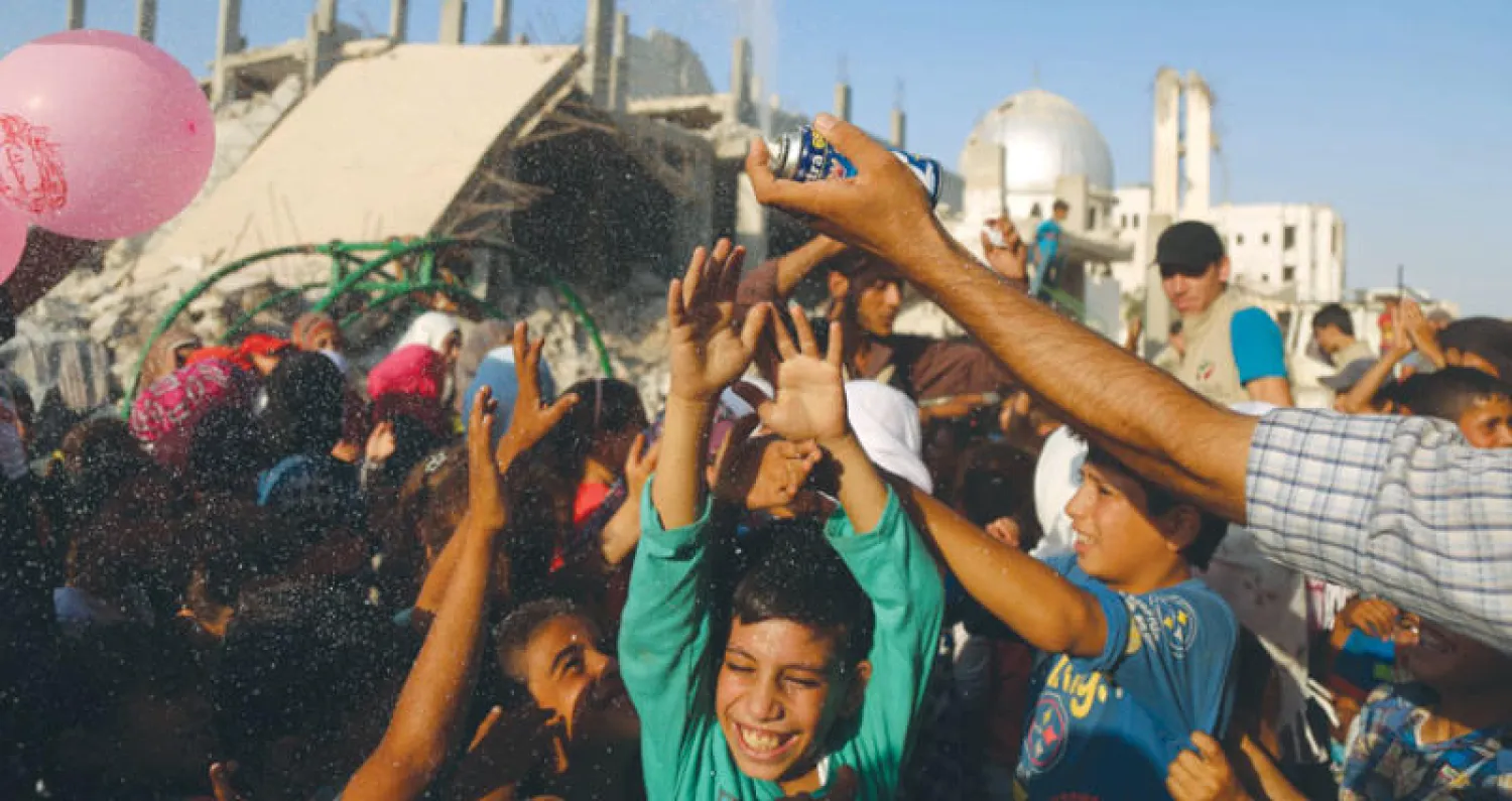 أطفال من دوما بالغوطة الشرقية لدمشق يلهون في عيد الأضحى (أ.ف.ب)