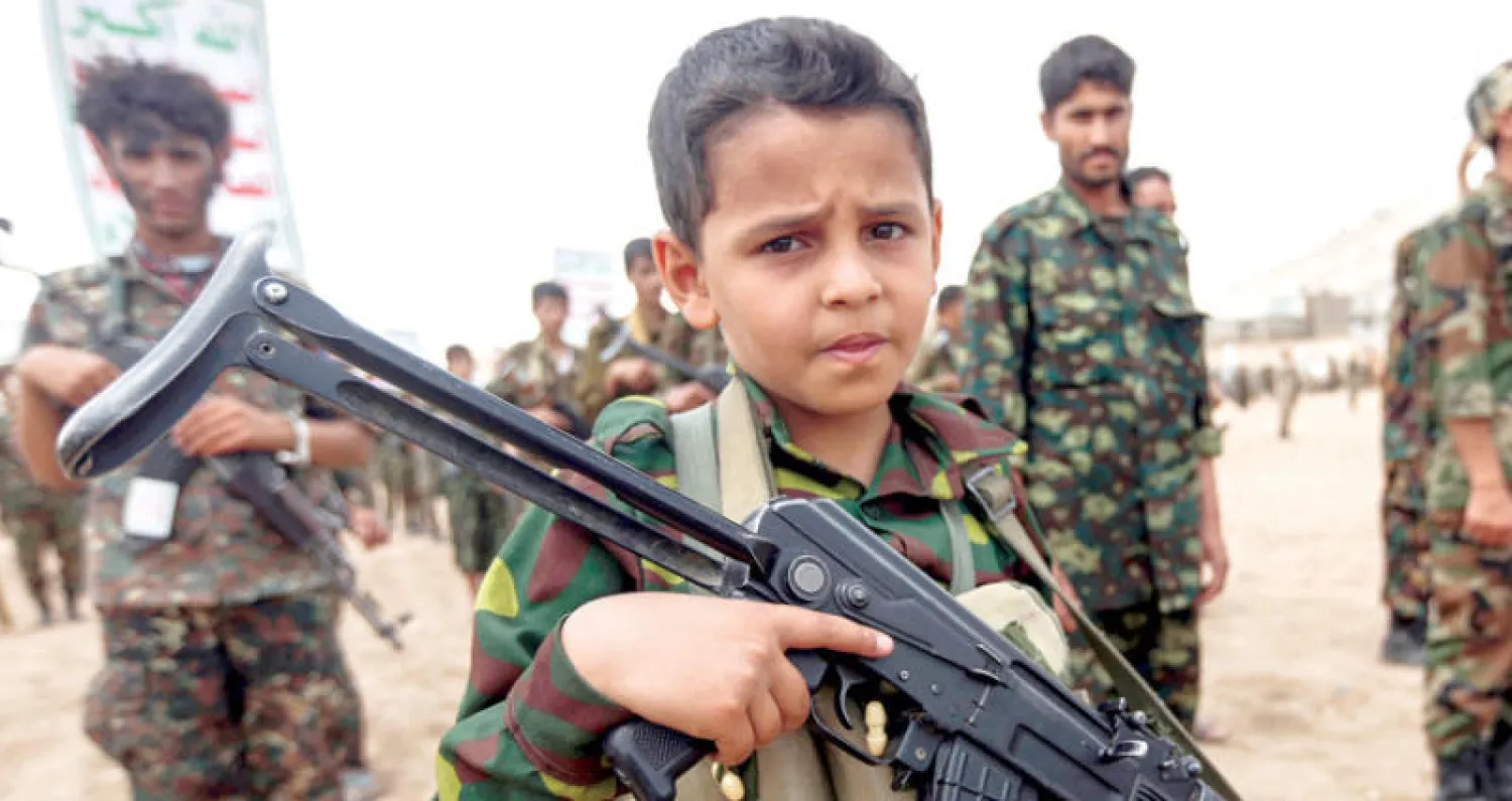 طفل يمني يحمل سلاحاً في استعراض لأتباع الحوثي وصالح في صنعاء (أ.ف.ب)