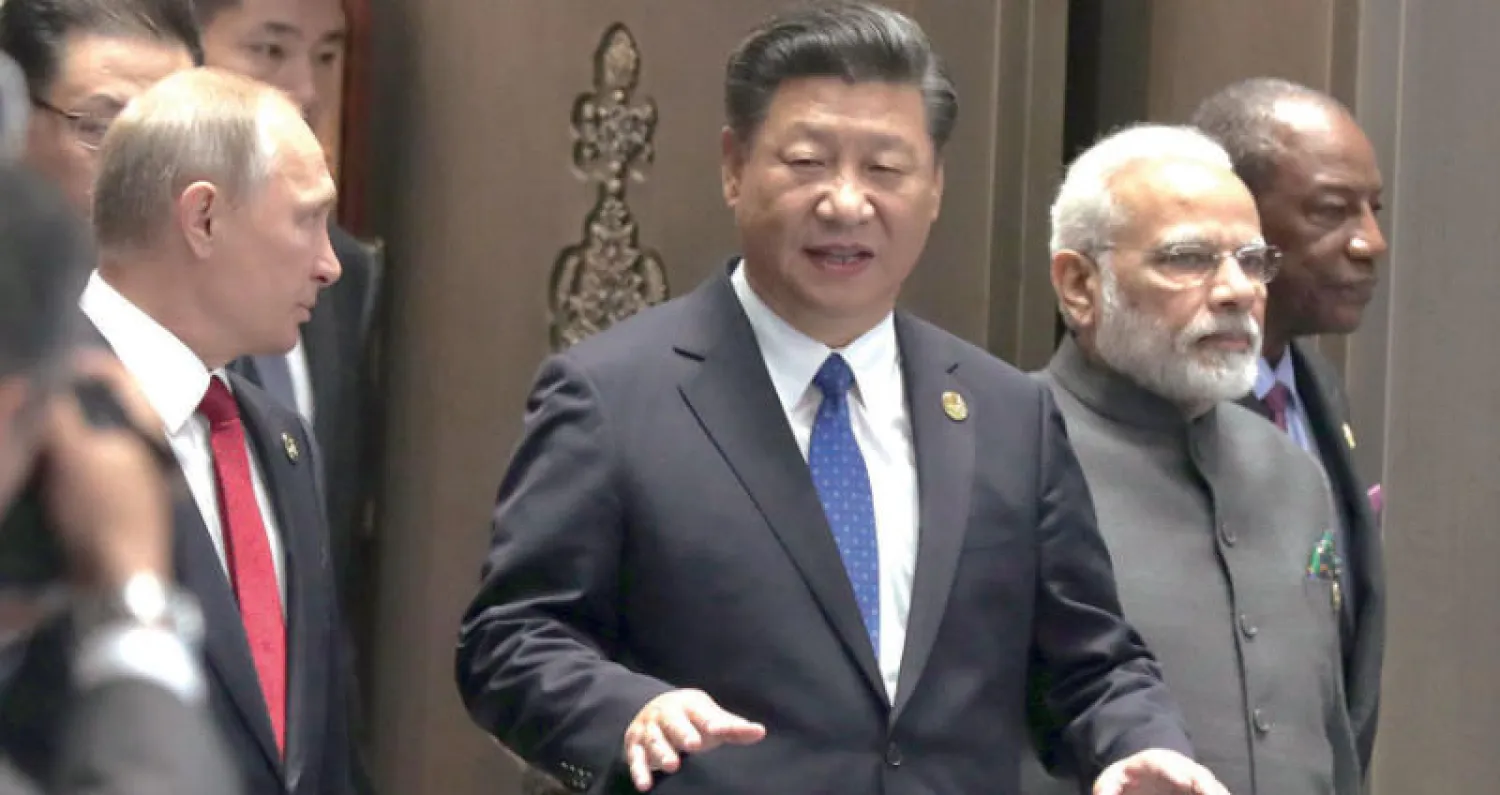 الرئيس الصيني شي جينبينغ في قمة «بريكس» يتوسط نظيره الروسي بوتين وخصمه اللدود رئيس الوزراء الهندي مودي (إ.ب.أ)