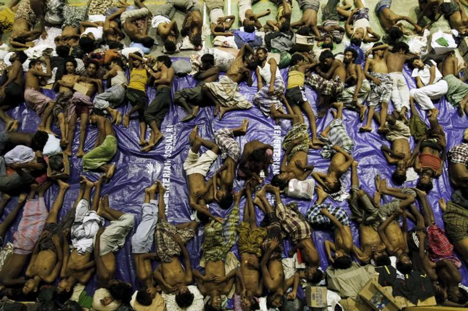 Migrants believed to be Rohingya rest inside a shelter after being rescued from boats at Lhoksukon in Indonesia's Aceh Province May 11, 2015. Nearly 600 migrants thought to be Rohingya refugees from Myanmar were rescued from two wooden boats stranded off the coast of Indonesia's northern Aceh province, authorities said on Sunday. The overcrowded boats, which were carrying nearly 100 women and dozens of children among the refugees, were towed to shore by fishermen after running out of fuel. REUTERS/Roni Bintang