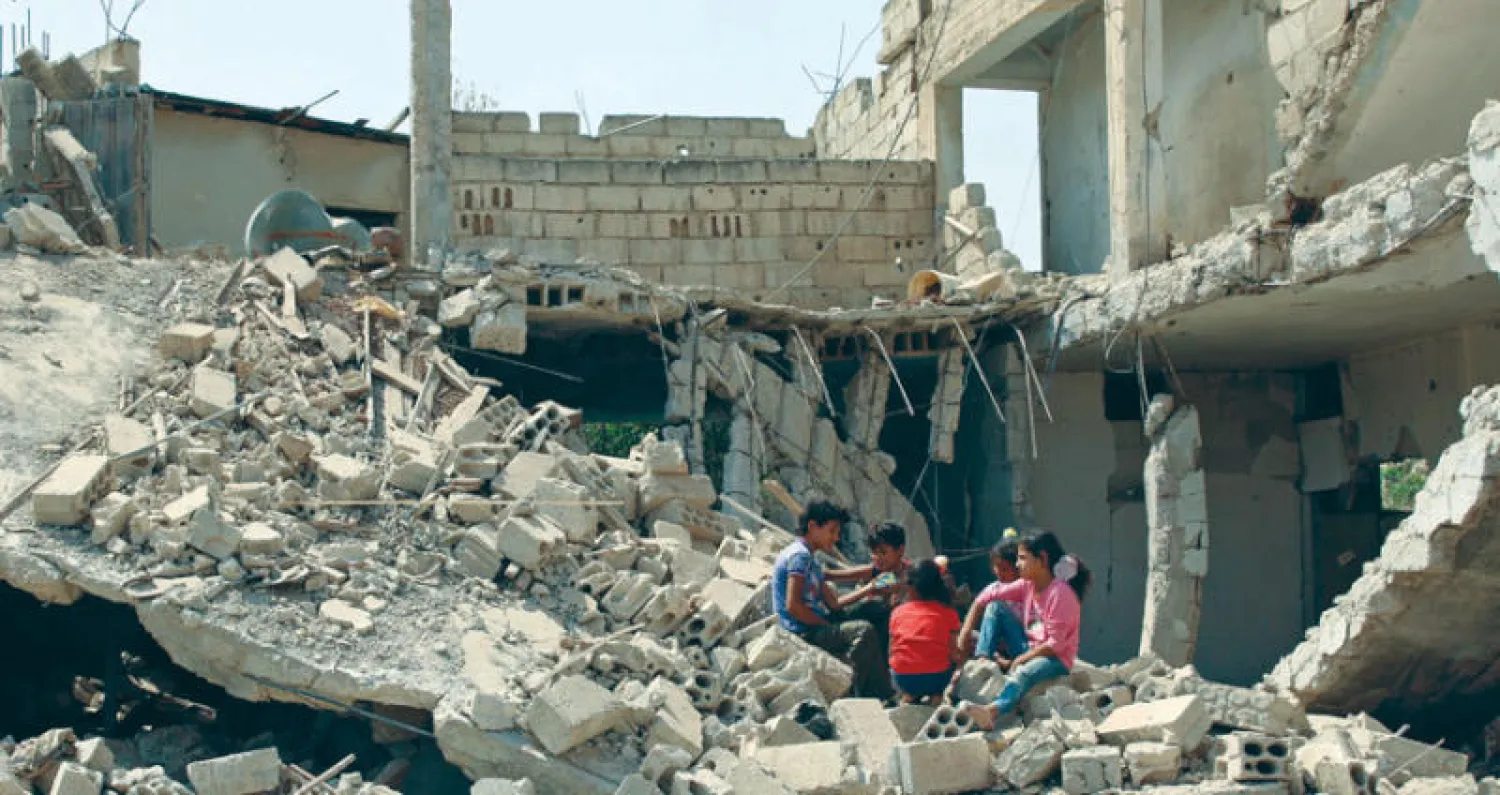 أطفال يلهون بين الدمار في درعا أمس (رويترز)