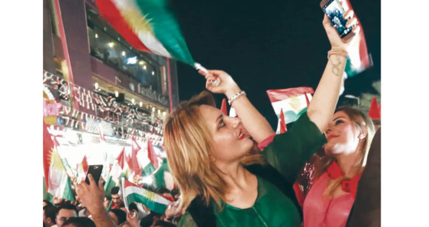 فتاة كردية تلتقط «سيلفي» خلال تجمع شعبي دعماً لاستفتاء الاستقلال في أربيل الليلة قبل الماضية (أ.ف.ب)