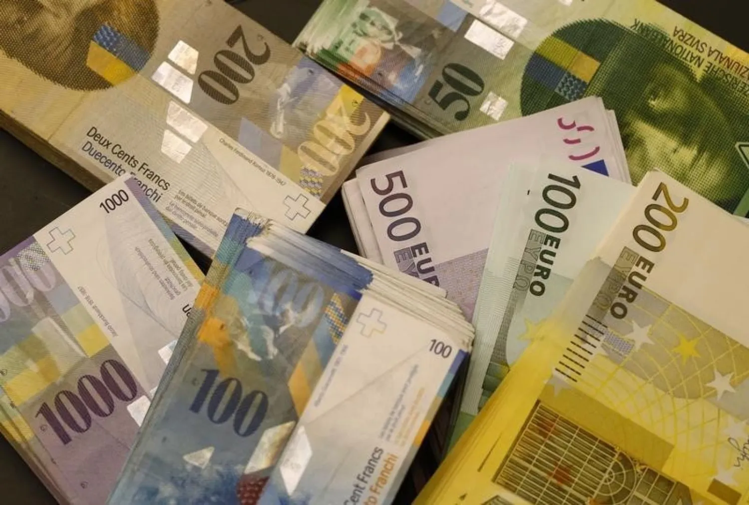Swiss Franc and Euro banknotes of several values lie on a table in a Swiss bank in Bern. Photo: Reuters