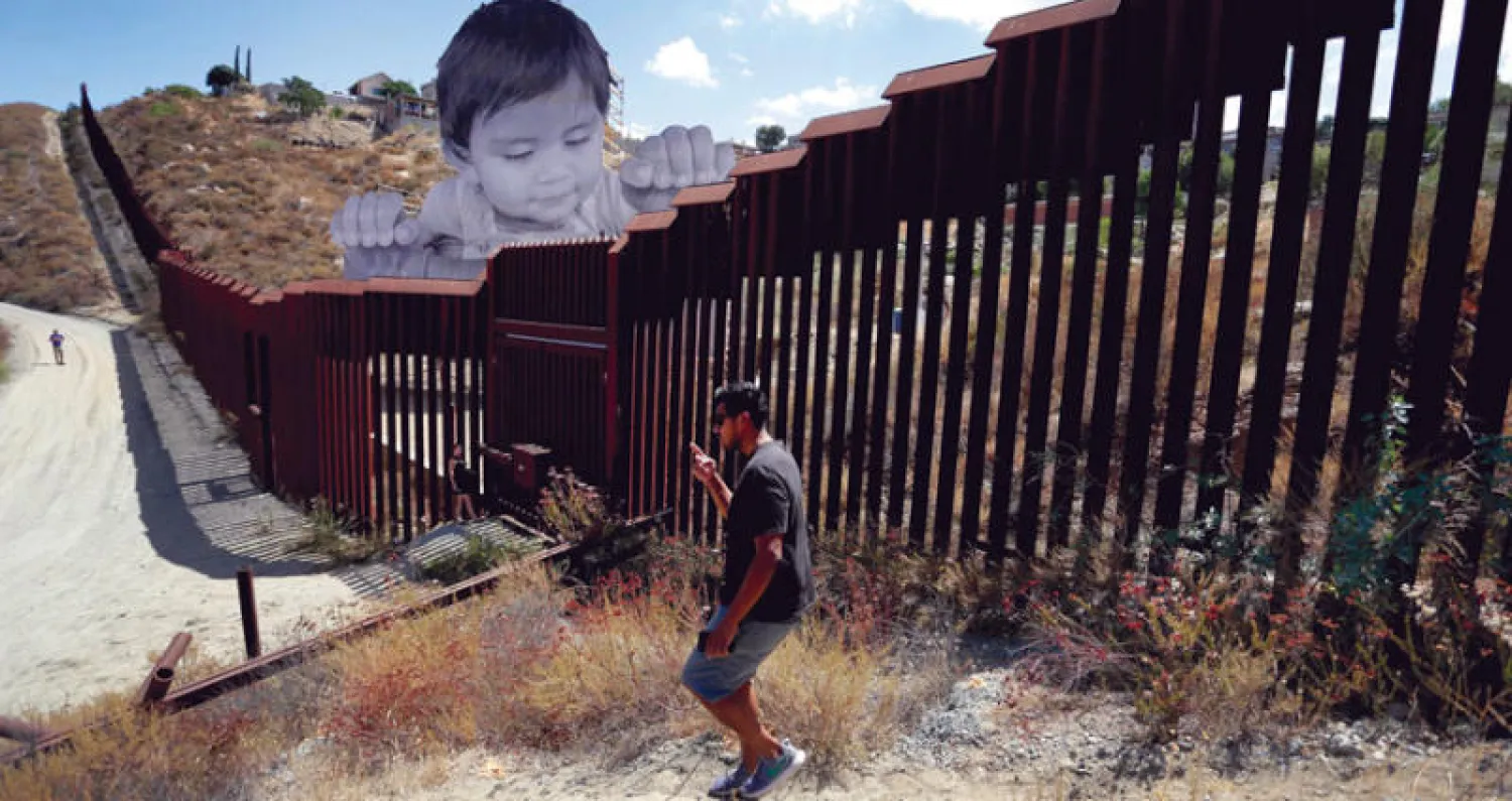 عمل لفنان فرنسي على الجدار العازل بين المكسيك وكاليفورنيا (إ.ب.أ)