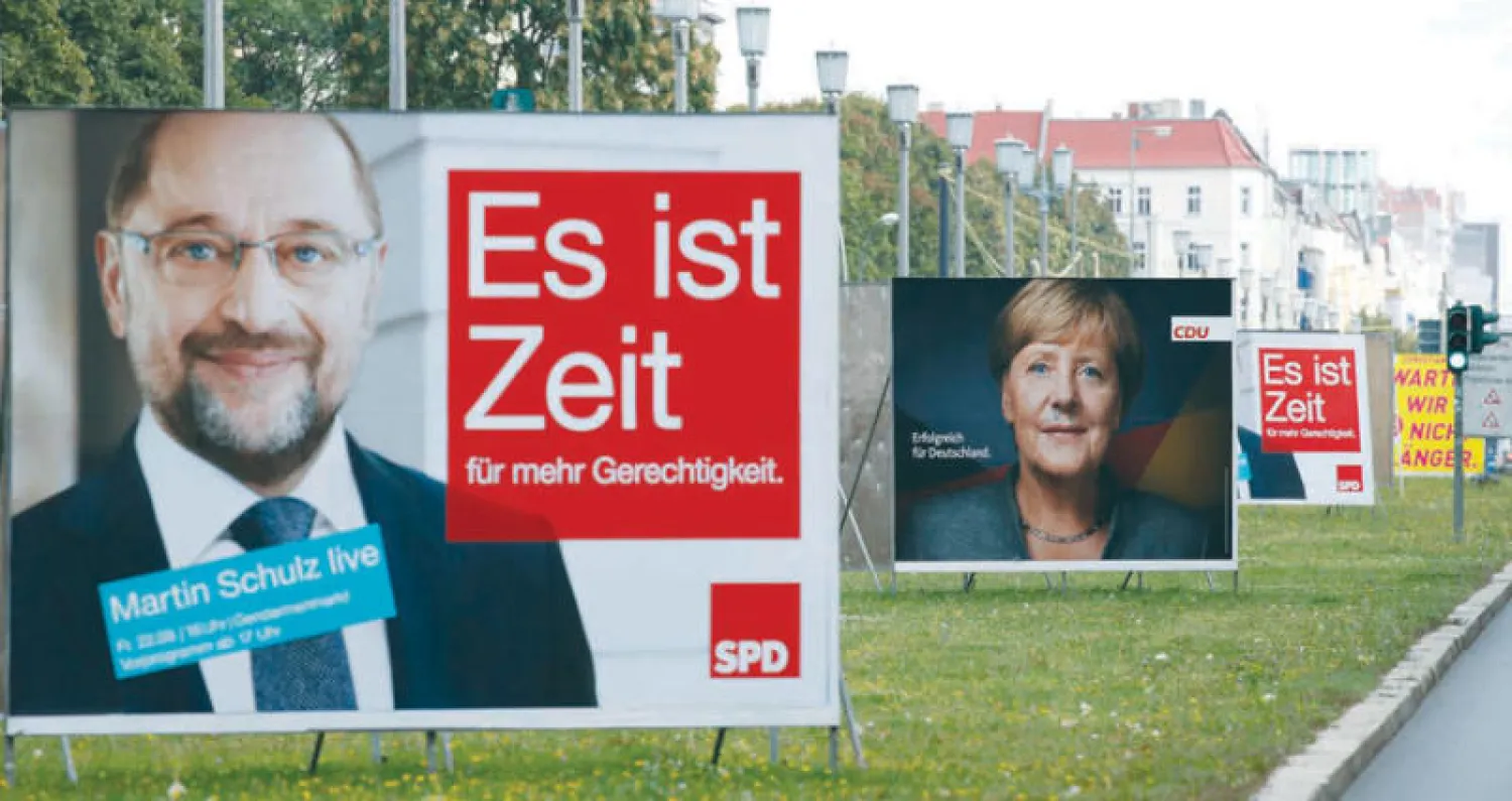 لافتات لميركل والاشتراكي شولتز (رويترز)