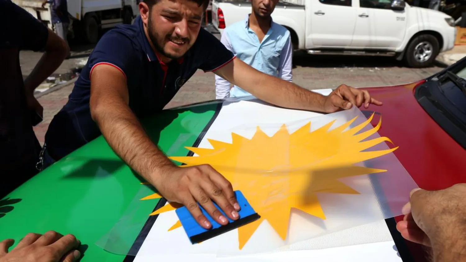 An Iraqi Kurdish man decorates a car with the Kurdish flags ahead of the upcoming independence referendum in Irbil. (AFP)