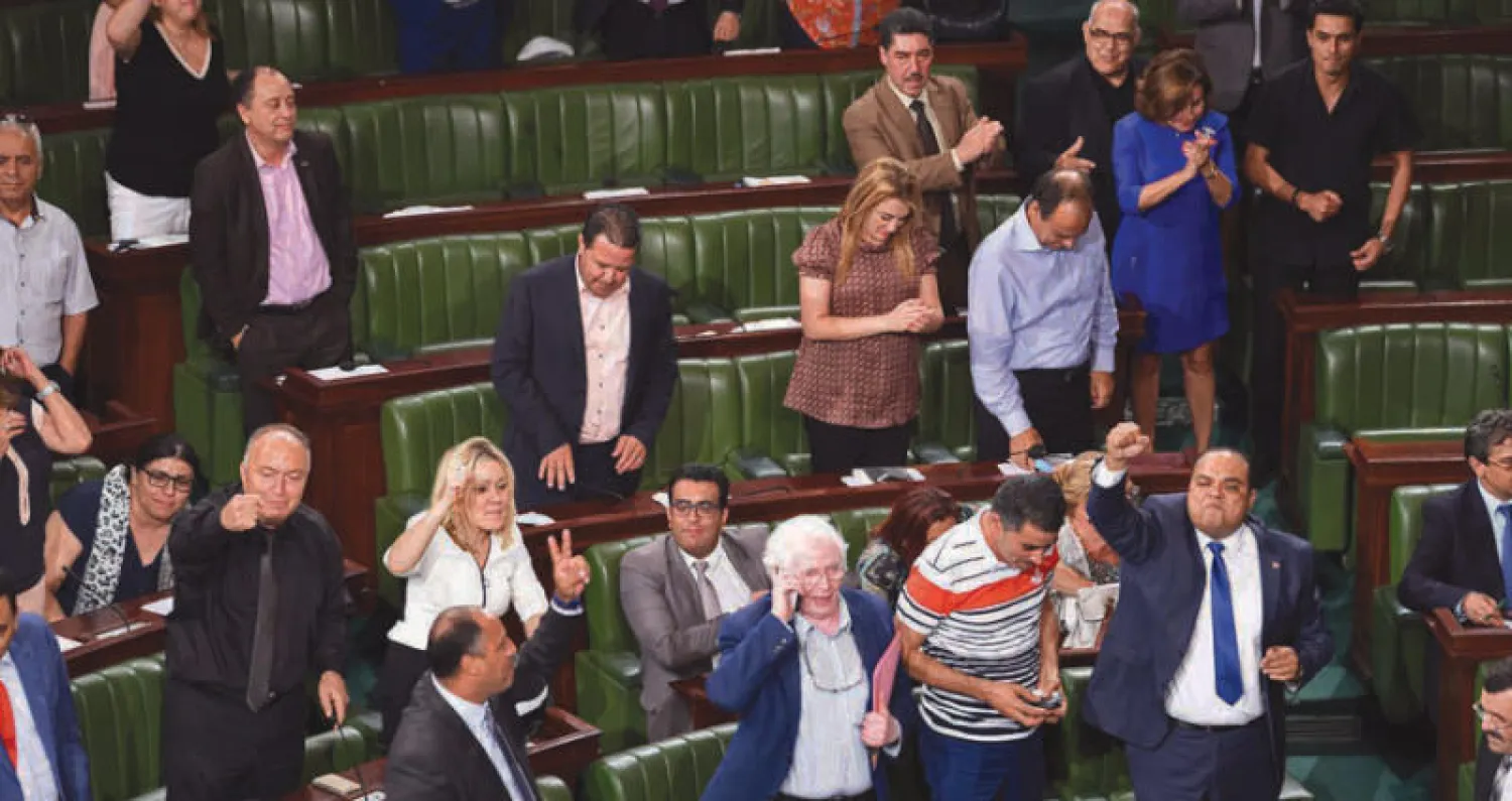 نواب من {نداء تونس} وحزب النهضة يعبرون عن فرحتهم بعد اقرار قانون العفو في البرلمان مساء اول من امس (أ.ف.ب)