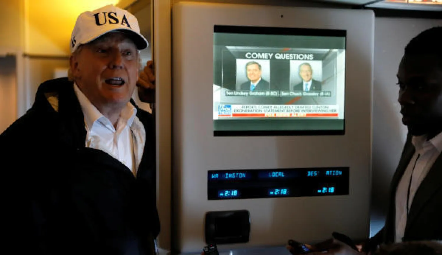 ترمب يتحدث للصحفيين على متن طائرة الرئاسة الأميركية في طريقه إلى واشنطن (رويترز)