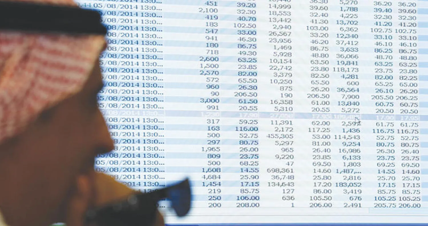 متعامل ينظر إلى أسعار الأسهم من خلال شاشة ضخمة في أحد البنوك في الرياض (رويترز)