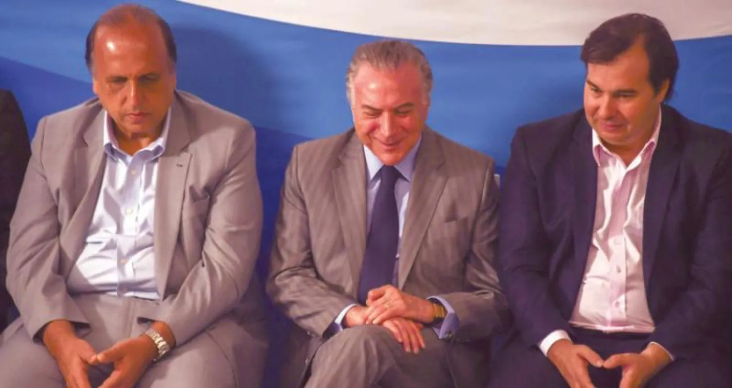 الرئيس ميشال تامر يتوسط حاكم ريو دي جانيرو لويز فيرناندو بيزاو (يسار) ورئيس الغرفة السفلى في البرلمان رودريغو ماريا خلال حضورهم مؤتمراً في العاصمة برازيليا أمس (أ.ف.ب)