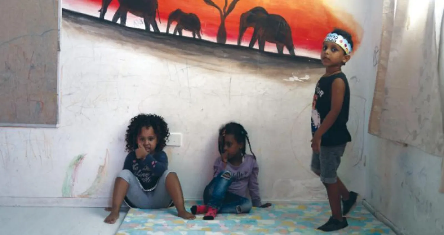 أطفال من إريتريا يلعبون في روضة مؤقتة جنوب تل أبيب (أ.ف.ب)