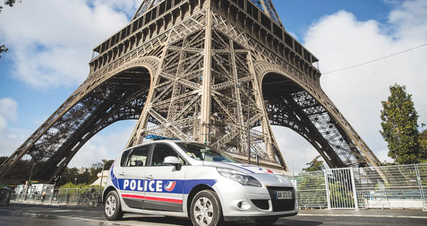 سيارة شرطة فرنسية خارج الحائط الزجاجي الجديد حول برج إيفل  أبرز المعالم السياحية الفرنسية بهدف حمايته من الرصاص (إ.ب.أ)