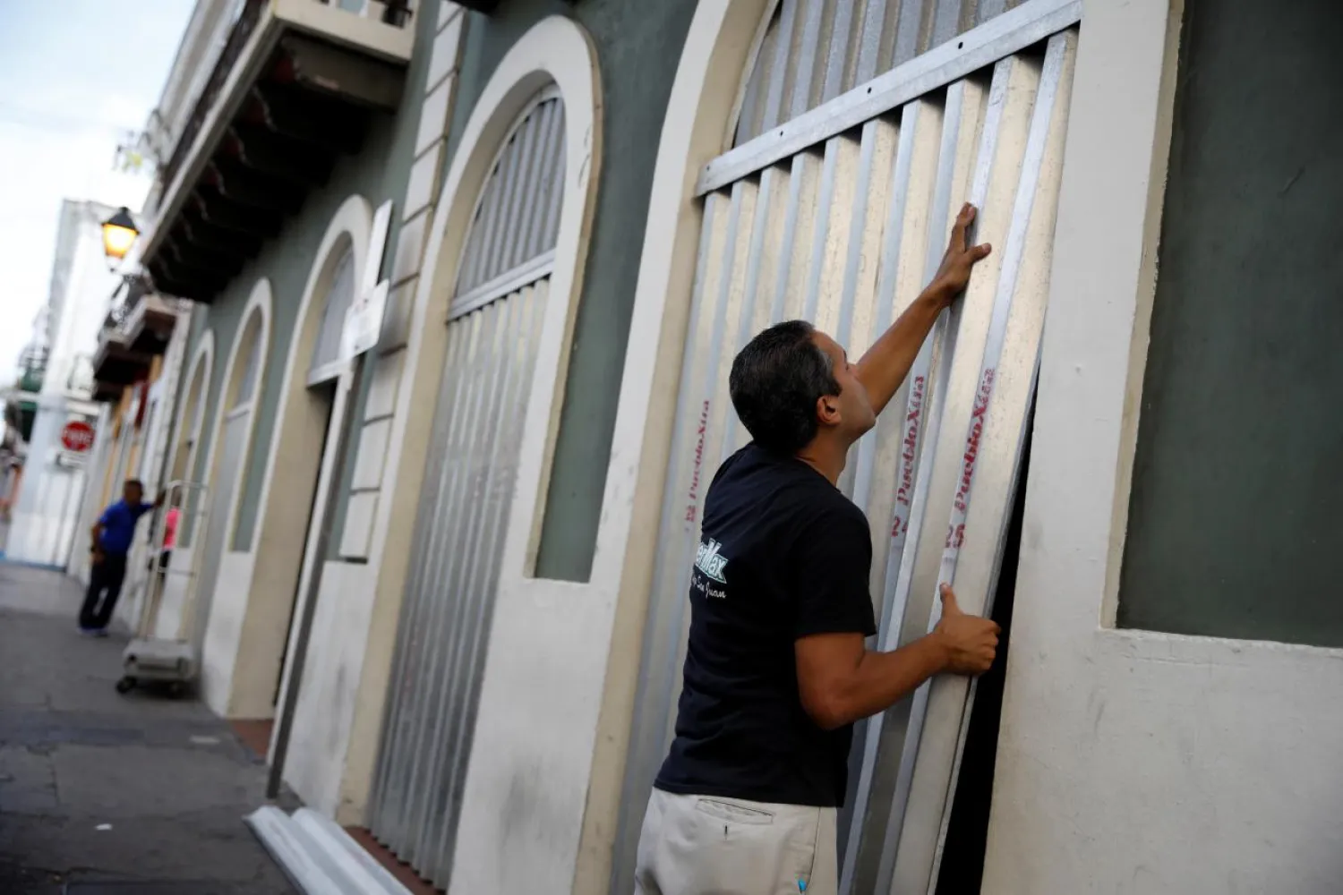 A man covers the windows of a supermarket in preparation for Hurricane Maria in San Juan, Puerto Rico September 19, 2017. REUTERS/Carlos Garcia Rawlins