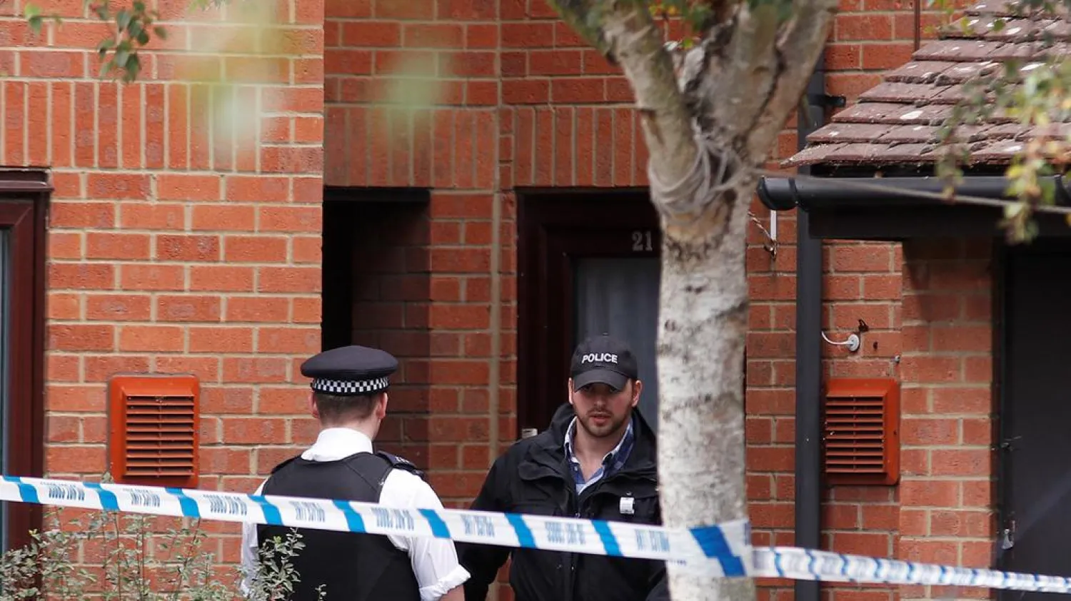 Police officers stand outside a property being searched after a man was arrested in connection with an explosion on a London Underground train, in Stanwell, near Heathrow airport. Peter Nicholls/Reuters